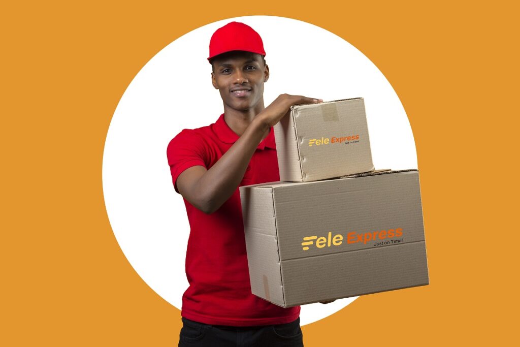 Young African American Delivery Man Wearing Red Polo Shirt And Cap Holding Boxes Looking At Camera With Big Smile Over Isolated Orange Background